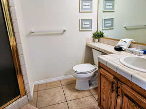 Bathroom with vanity, a shower stall, and light tile patterned flooring