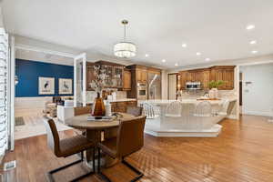 Dining space with recessed lighting, light wood-style flooring, and wainscoting