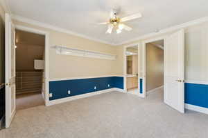 Spare room with light carpet, crown molding, and a ceiling fan