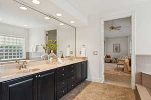 Ensuite bathroom with ornamental molding, double vanity, recessed lighting, and ceiling fan