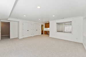 Bonus room with light colored carpet and recessed lighting