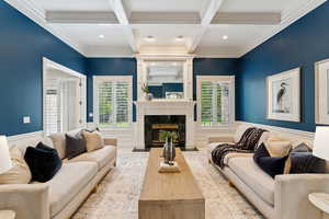 Living room with beamed ceiling, ornamental molding, a premium fireplace, coffered ceiling, and recessed lighting