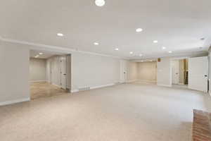 Finished below grade area with recessed lighting, light colored carpet, and ornamental molding