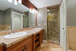 Bathroom with a stall shower, double vanity, and light tile patterned floors