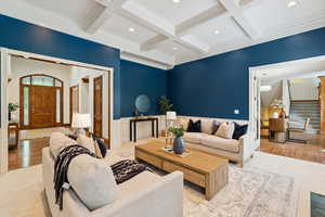 Living room featuring stairway, beamed ceiling, coffered ceiling, wood finished floors, and recessed lighting