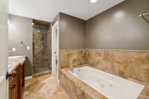 Full bathroom with a whirlpool tub, a shower stall, and double vanity