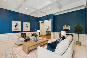Living area featuring a decorative wall, wainscoting, beam ceiling, and recessed lighting