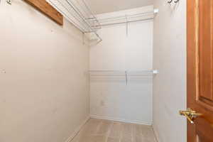 Walk in closet featuring light colored carpet