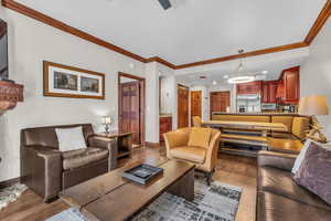 Living area with crown molding, wood finished floors, and recessed lighting