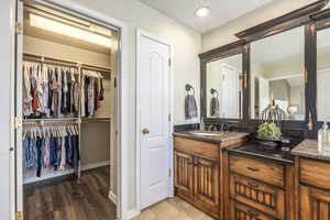 Bathroom with vanity, light wood-type flooring, recessed lighting, and a walk in closet