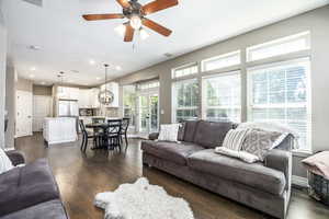 Living room featuring dark wood-type flooring, recessed lighting, and ceiling fan