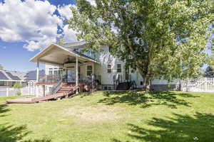Rear view of property with a fenced backyard, stairs, a wooden deck, and ceiling fan