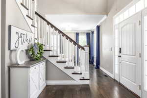 Entryway with stairs, dark wood-style floors, and crown molding
