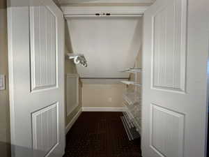 Spacious closet with dark carpet