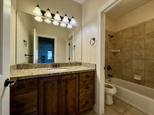 Bathroom featuring shower / tub combination, vanity, and light tile patterned floors