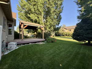 View of grassy yard featuring a deck