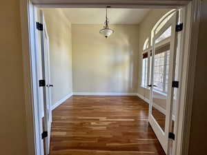 Unfurnished dining area featuring french doors and wood finished floors