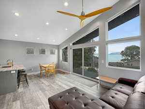 Living area featuring recessed lighting, light wood-style floors, a mountain view, and a ceiling fan