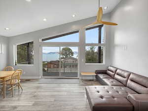 Living room with a mountain view, light wood-style floors, recessed lighting, and high vaulted ceiling