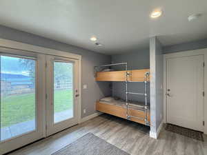 Bedroom with light wood-style flooring, access to exterior, and recessed lighting