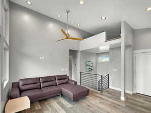 Living area featuring recessed lighting, ceiling fan, a high ceiling, and light wood-type flooring