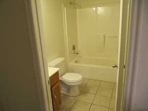 Bathroom featuring light tile patterned flooring, vanity, and shower / washtub combination