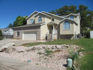 View of front of home with a garage, concrete driveway, and brick siding