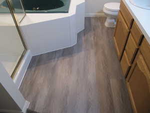 Full bath featuring dark wood-style flooring, a shower stall, vanity, and a garden tub