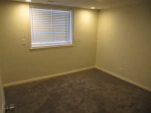 Unfurnished room with dark carpet, a paneled ceiling, and recessed lighting