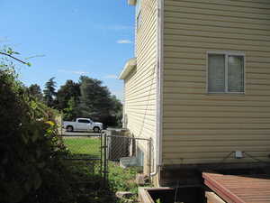View of property exterior featuring a central AC unit and a gate