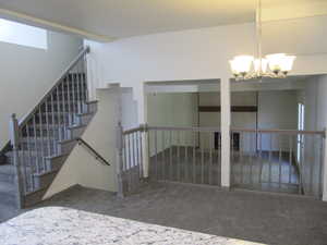 Stairs featuring carpet flooring and a chandelier