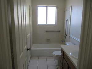Bathroom with shower / washtub combination, vanity, and light tile patterned floors