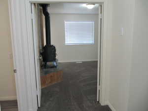 Hall featuring dark colored carpet