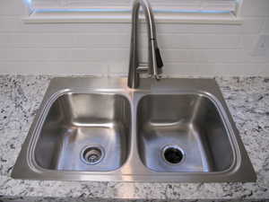 Kitchen view of light stone countertops and decorative backsplash