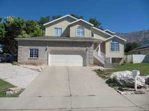 Traditional-style house with concrete driveway, a garage, a mountain view, and brick siding