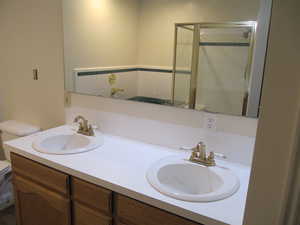Bathroom featuring double vanity and a stall shower