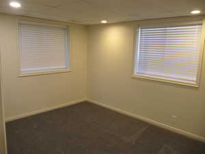 Empty room featuring dark carpet and recessed lighting