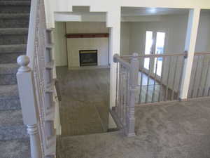 Stairway with tile patterned floors, a tile fireplace, and carpet floors