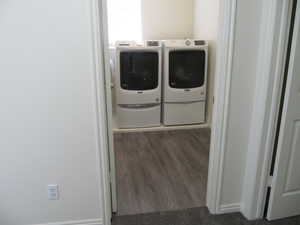 Laundry area with independent washer and dryer and dark wood-style flooring