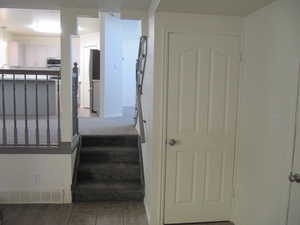 Stairway with baseboards and tile patterned flooring