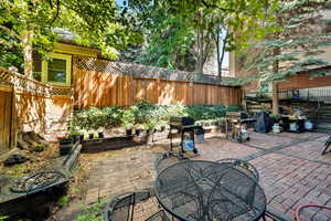 Fenced backyard featuring a patio, outdoor dining area, and a grill