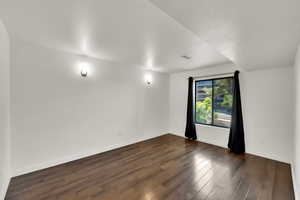 Empty room featuring dark wood finished floors and a textured ceiling