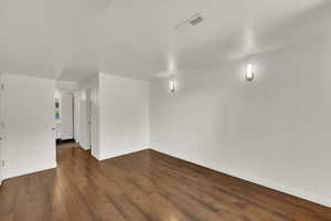 Empty room with dark wood finished floors and baseboards