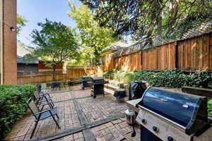 Fenced backyard with area for grilling and a patio