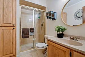 Full bath featuring a stall shower, vanity, and light tile patterned floors