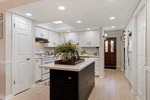 Kitchen with white cabinets, white appliances, tasteful backsplash, recessed lighting, and ornamental molding