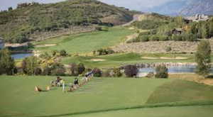 View of home's community with view of golf course, a water and mountain view, and a yard