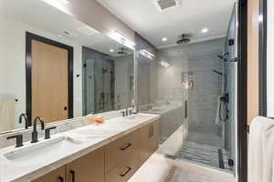 Full bath featuring a shower stall, double vanity, light tile patterned floors, and recessed lighting