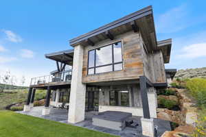Back of house with a patio and a balcony