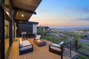 Deck with a fire pit, a grill, and a mountain view